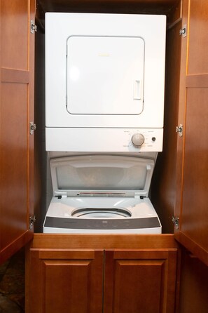 A compact, wall-mounted washer and dryer unit with a control panel and a transparent door.
