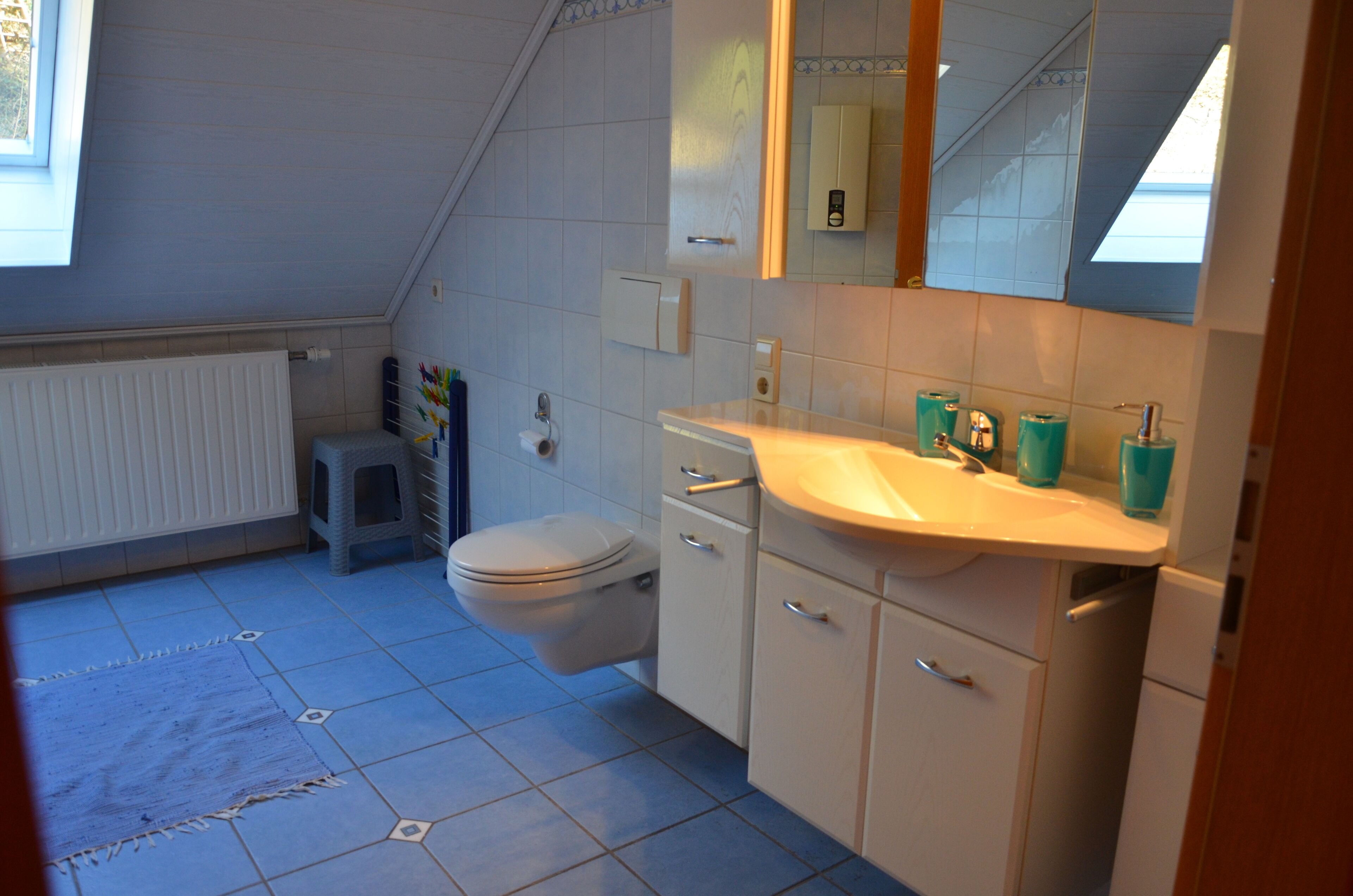 A small, clean bathroom with a toilet, sink, and mirror.
