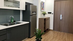 Une cuisine moderne dotée d’un réfrigérateur en acier inoxydable, d’un évier à deux bacs et d’armoires en bois.
