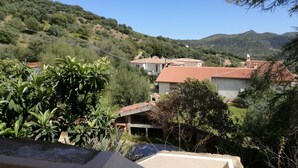 A hillside residential area with houses featuring red-tiled roofs, surrounded by greenery and hills. - Holidays in San Teodoro (San teodoro)