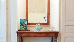 Ein Konsolentisch aus Holz mit einem Spiegel darüber, einer Vase und einem gerahmten Bild auf der linken Seite.