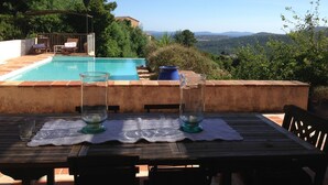 A poolside table with two glasses and a candle, overlooking a swimming pool and lush greenery. - Villa with swimming pool in the Gulf of SAINT-TROPEZ (La Croix-Valmer)