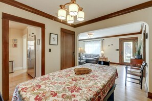 A spacious bedroom with a large bed, a wooden ceiling, and a view to the living area.