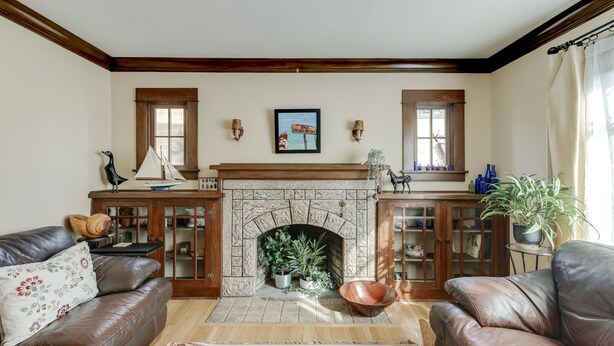 A living room with a stone fireplace, leather sofas, and a wooden mantelpiece. - Gorgeous 3 bed/ 2 bath home in the heart of Sellwood! Walk to everything! (Portland)