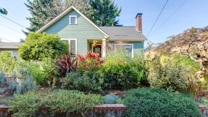 A house with a stone retaining wall, a variety of plants, and a clear blue sky. - Gorgeous 3 bed/ 2 bath home in the heart of Sellwood! Walk to everything! (Portland)