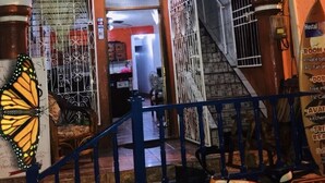 A hostel entrance with a signboard advertising Wi-Fi and a contact number. - Hostal Brisas y Olas - Hostel (San Juan del Sur)