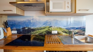 Una cocina equipada con microondas, estufa y lavabo.