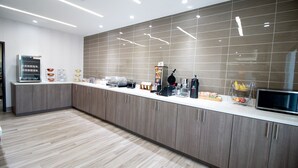 A modern kitchen with a long counter, built-in appliances, and a tiled backsplash. - Hotel Pryor (Pryor)