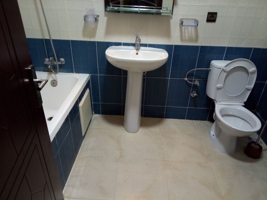 Un baño con lavamanos, inodoro y bañera.