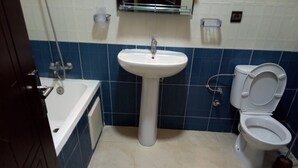 Een badkamer met een wastafel, toilet en bad.