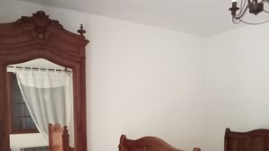 Un dormitorio con una cama de madera, un espejo grande y una araña.