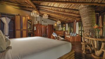 Ein Zimmer mit einem großen Bett, Holzmöbeln und einer einzigartigen Strohdecke.