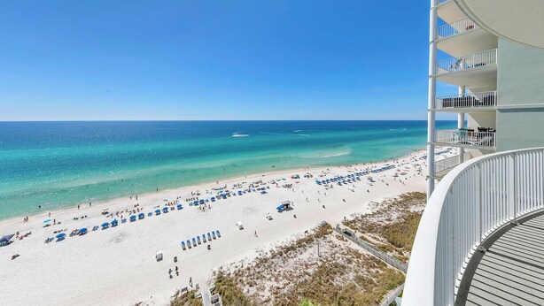 A beach view from a hotel balcony with a clear sky, a sandy beach with umbrellas, and the ocean. - 🏖️Gulf Front-Free Beach Chairs-2BR Twin Palms 1401🏖️ (Panama City Beach)