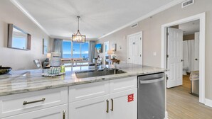 A modern kitchen with a large island, white cabinetry, and a stainless steel dishwasher. - 🏖️Gulf Front-Free Beach Chairs-2BR Twin Palms 1401🏖️ (Panama City Beach)