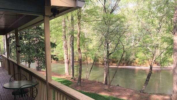 A covered deck with a view of a lake and trees. - Chestatee River Cabin (Dahlonega)