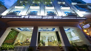 The exterior of the Blue Diamond Luxury Hotel with a grand entrance, a well-lit facade, and a staircase leading up to the lobby. - Diamond Hill Hotel (Ho Chi Minh City)