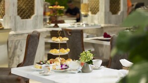 A dining table with a tiered dessert stand, tea set, and floral centerpiece. - Diamond Hill Hotel (Ho Chi Minh City)