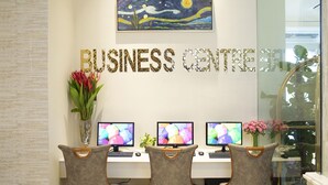 A business center with three computer workstations, a large painting above the 'BUSINESS CENTRE' sign, and a vase with flowers on the desk. - Diamond Hill Hotel (Ho Chi Minh City)