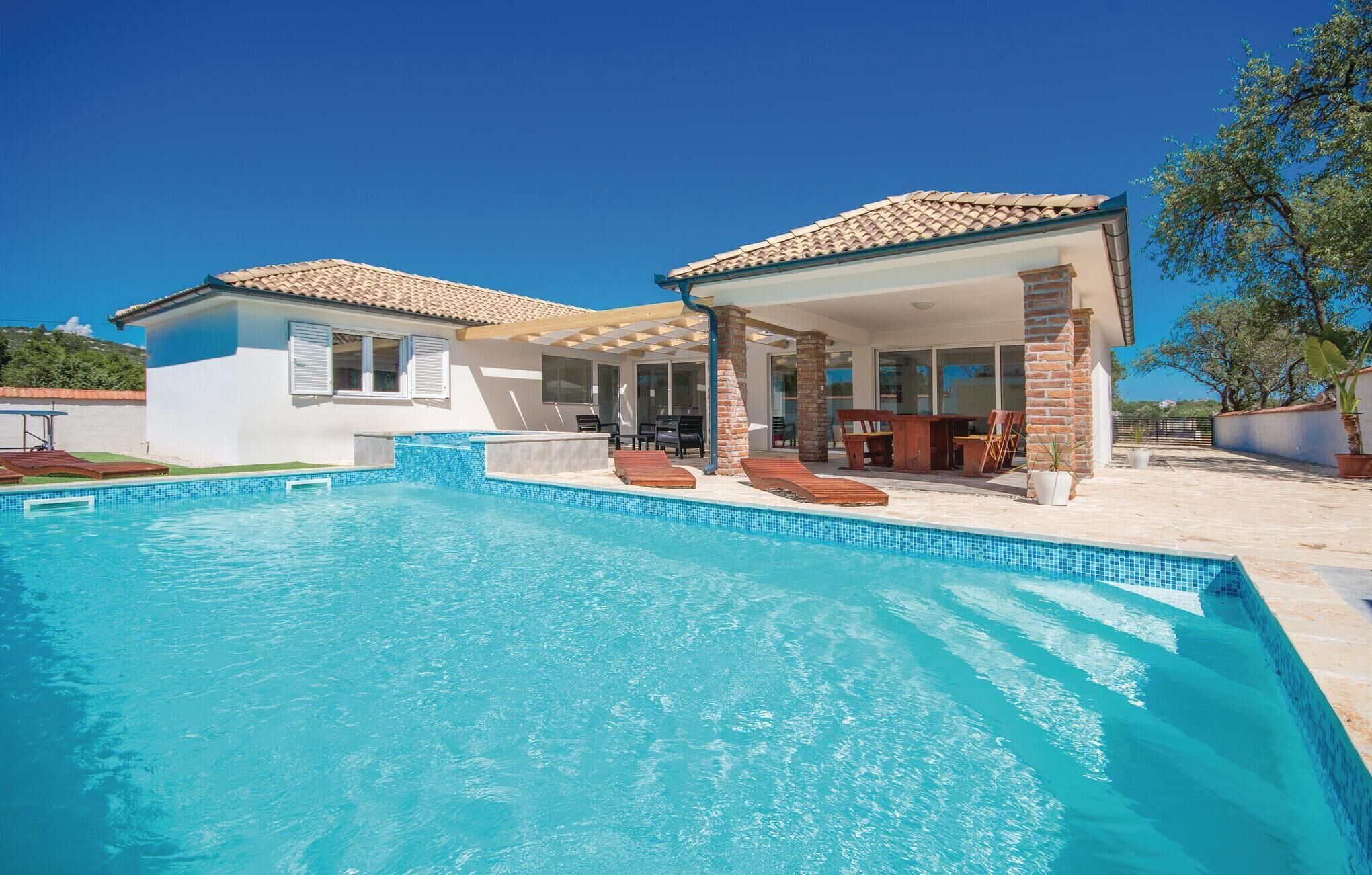 A two-story house with a swimming pool, outdoor seating, and a patio area.