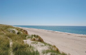 Enjoy serene beach walks along the shoreline, where grassy dunes meet the ocean.