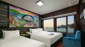 A hotel room with two beds, a large window with a view of the sea, and a mural with a fan. - Halong Fantasea Cruise (Tuan Chau)