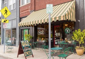 Sit outside at Carl's, where green metal chairs and tables await beneath a striped awning.
