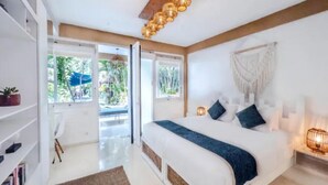 Un dormitorio moderno con una cama grande, techo de madera y vistas al exterior.