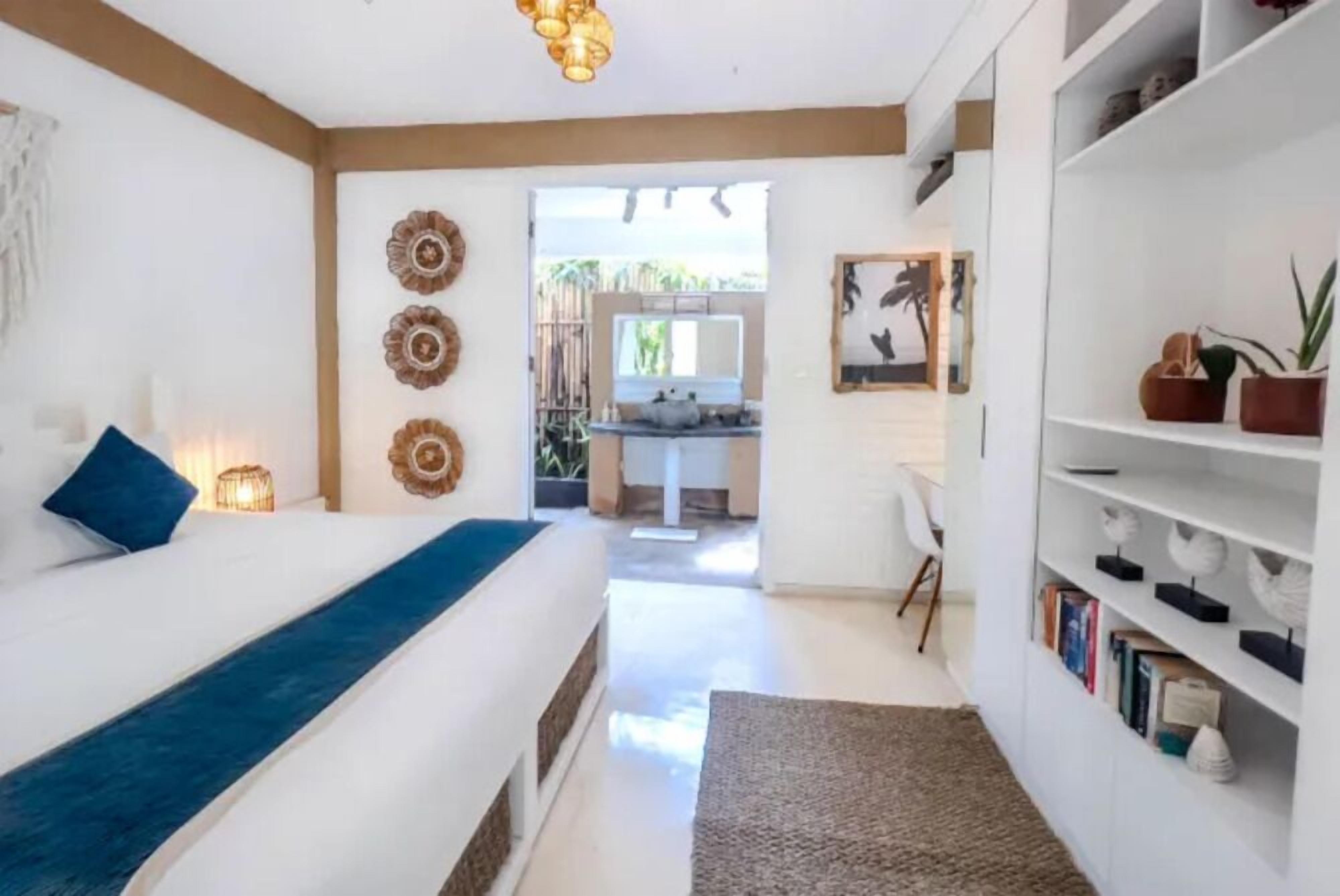 Ein Schlafzimmer mit Bett, Nachttisch und Bücherregal.