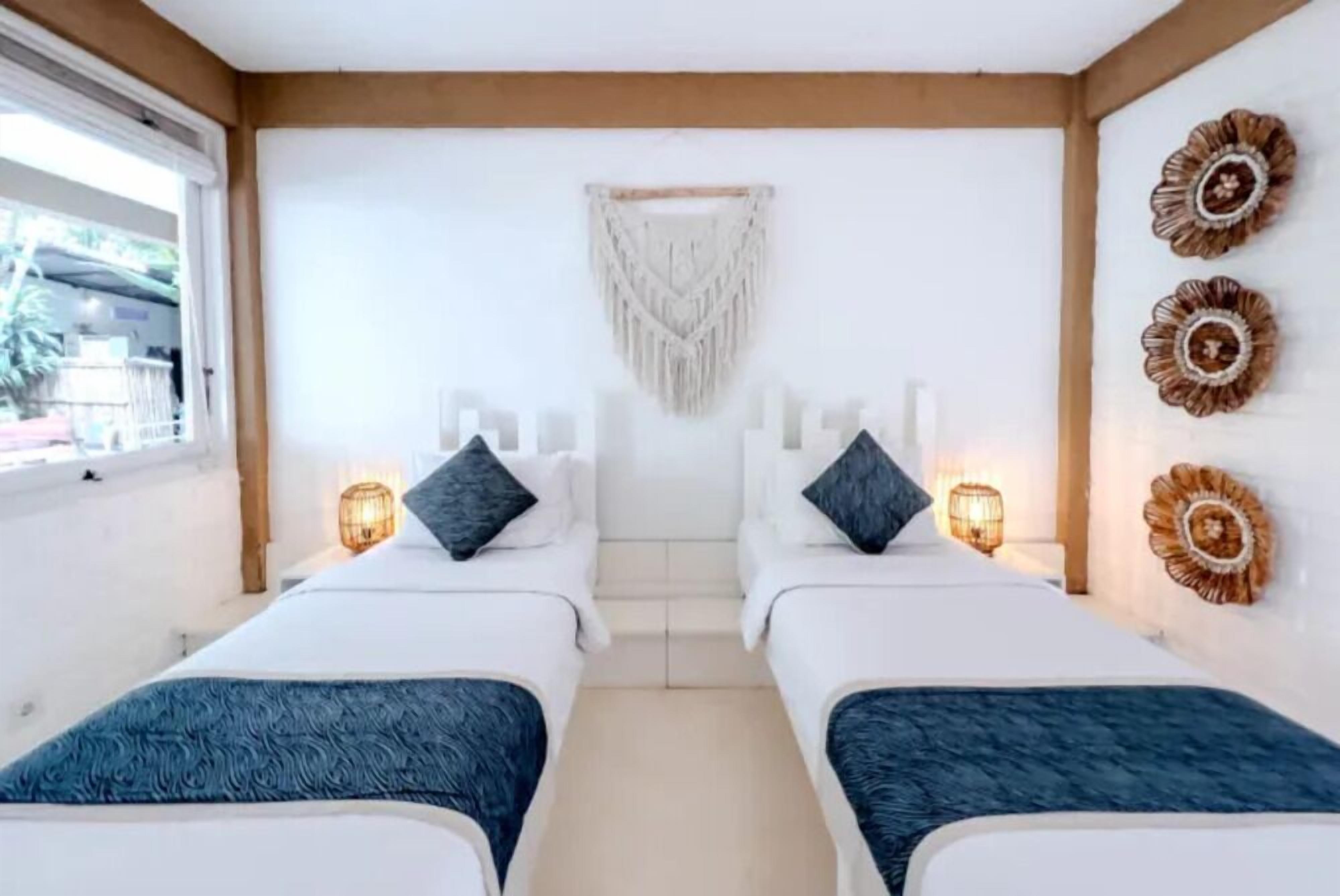 A hotel room with two beds, a large window, and decorative wall art.