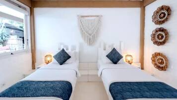 A hotel room with two beds, a large window, and decorative wall art.