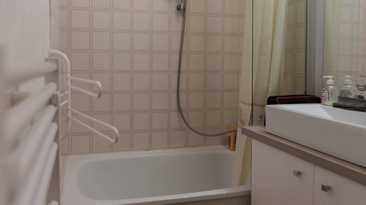 A bathroom with a bathtub, a shower, and a mirror.