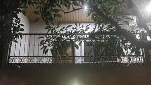A gated entrance with a sign reading 'Patio de Joan,' two potted plants, and a balcony with railings. - Patio De Joan (Comayagua)