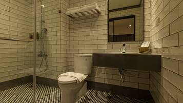 A bathroom with a toilet, sink, and shower.