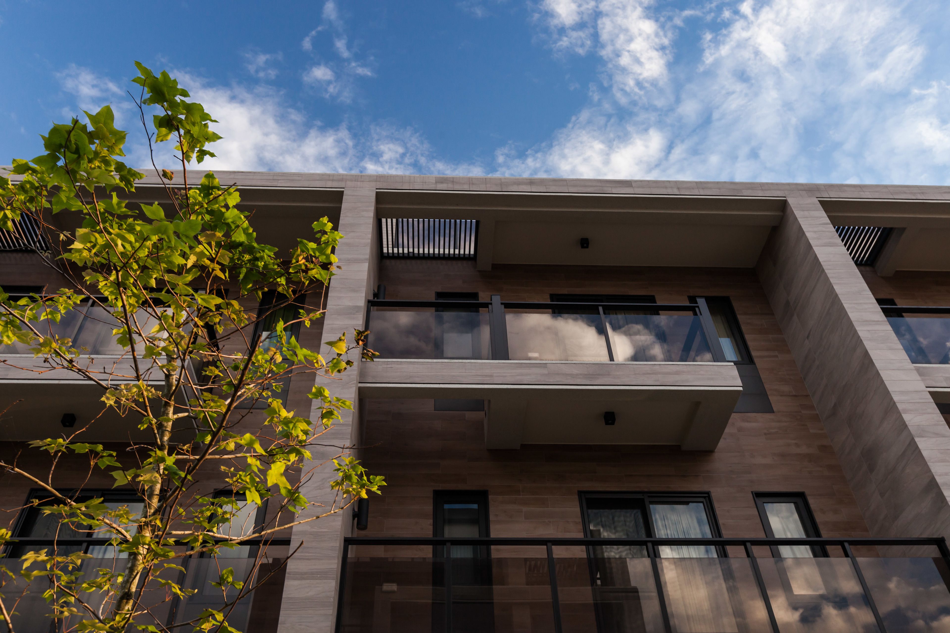 A modern building with multiple balconies and large windows.