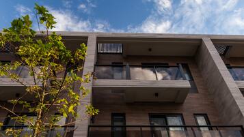 A modern building with multiple balconies and large windows.