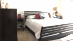 A bedroom with a bed, bedside table, and a dresser. - Beautiful lake view- (Lake Ozarks)