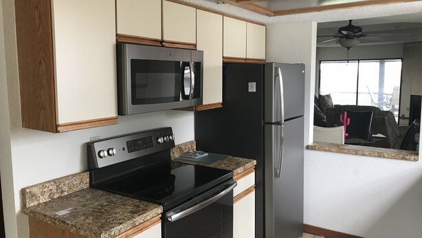A kitchen with a stainless steel microwave, refrigerator, and oven. - Beautiful lake view- (Lake Ozarks)