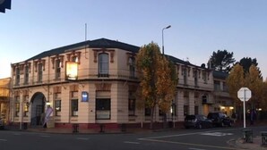 A historic building with a classic architectural style, featuring a symmetrical facade, arched windows, and a central entrance. - Geraldine Heritage Hotel (Geraldine)