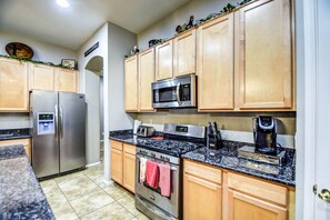 Enjoy cooking in this well-equipped kitchen with a refrigerator, microwave, stove, and coffee maker.