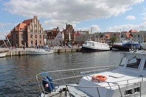 A marina with boats docked, a historic building, and a crowd of people.