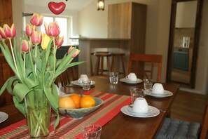 A dining table set with plates, glasses, and a bowl of fruit. - 3) Holiday apartment 4-room, upper floor, 110m² - Landhaus Alte Schule near (Alt Bukow)