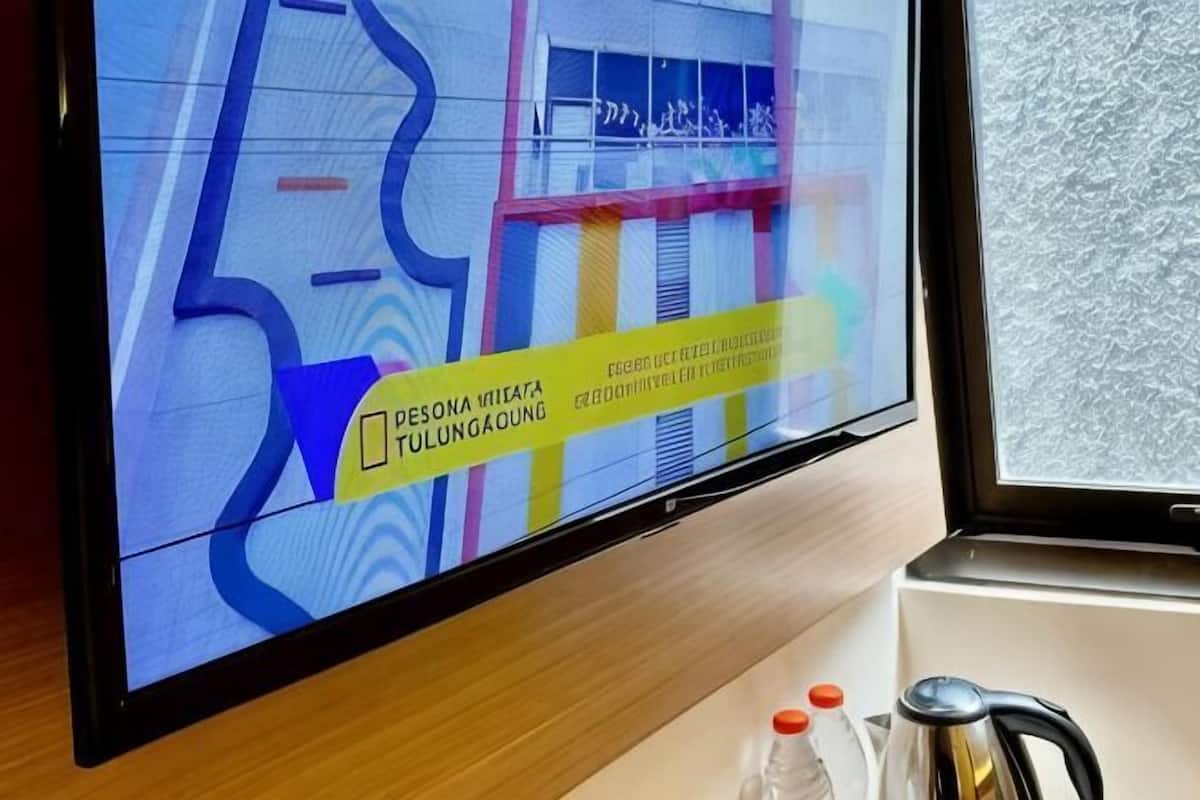 Una pantalla de televisión muestra la fachada colorida de un edificio con un letrero amarillo.