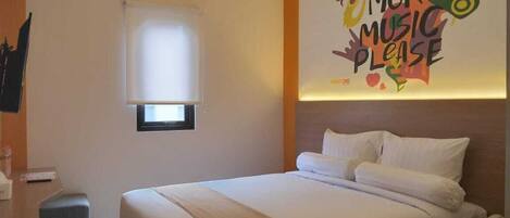 Una habitación de hotel con cama, mesita de noche y un adorno en la pared.