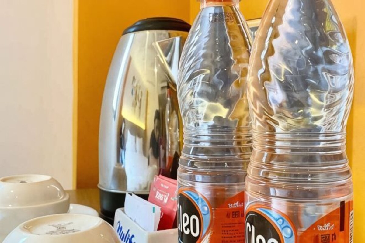A kitchen area with a kettle, a bottle of water, and a coffee machine.