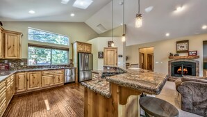 A spacious kitchen with wooden cabinets, a large island, and a built-in stove.