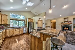 Enjoy cooking in this well-equipped kitchen with a large island countertop, oven, and refrigerator.