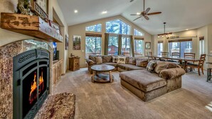 A spacious living room with a fireplace, a large sectional sofa, and a dining area with a table and chairs.