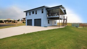 A modern two-story house with a garage, a covered balcony, and a staircase leading to an upper level. - 17 Sea Esplanade, Elliott Heads (ELLIOTT HEADS)