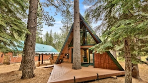 A cabin with a wooden deck, surrounded by tall trees. - Külhaus Cabin - Romantic A-frame Adventure, BBQ (South Lake Tahoe)