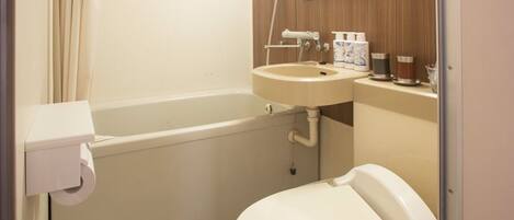 A small, compact bathroom with a toilet, sink, and bathtub.
